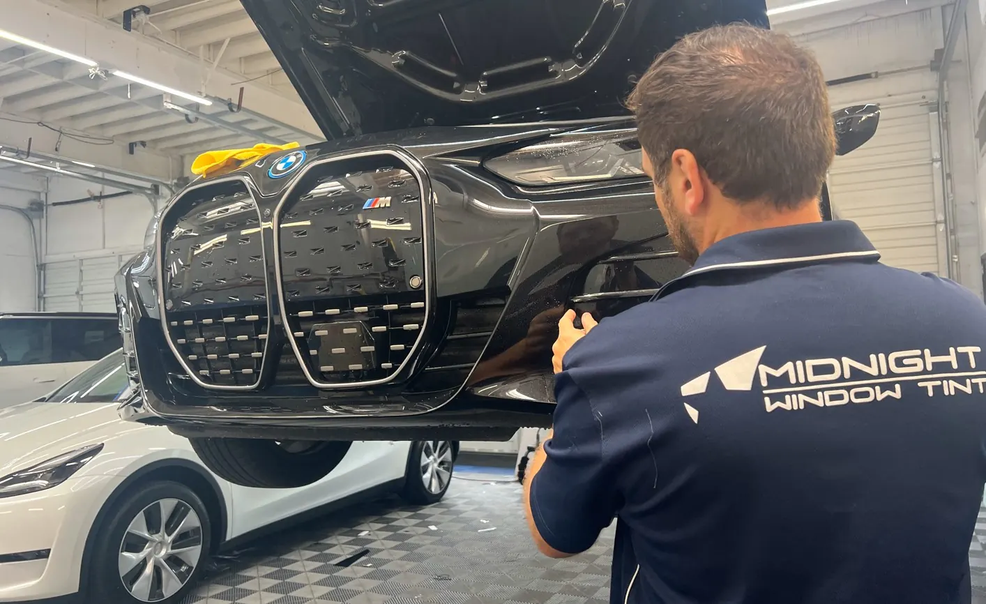Technician installing protection film on a headlight